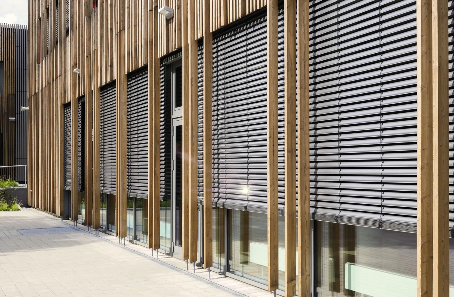 Moderne Holzfassade mit Jalousien an einem Bürogebäude